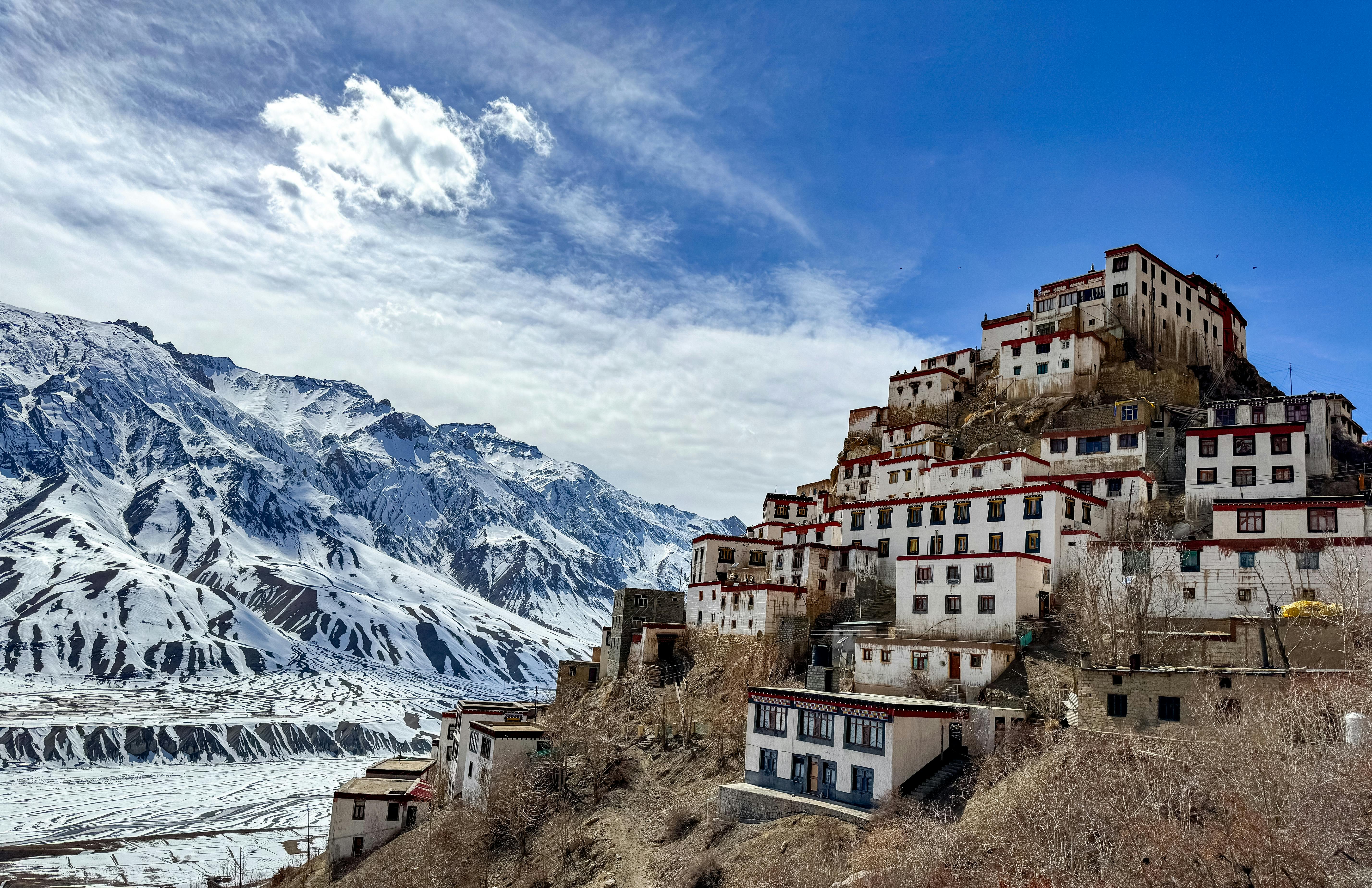 Mountain village in Spiti Valley with snow patches showing traditional houses in rough landscape